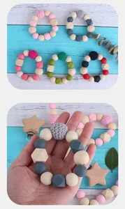 Detail of baby teething chain with natural wooden stars and colorful silicone beads
