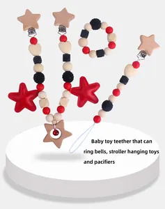 Detail of wooden star teether set with red and black silicone beads and baby rattle bell