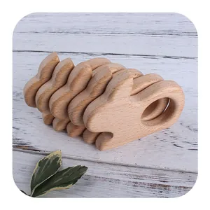 Five bunny shaped beech wood baby teethers and DIY accessories on white wood background