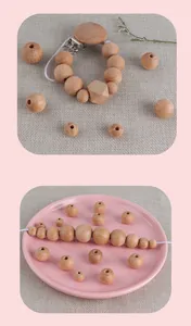 Macro shot of smooth natural beech wood beads and pacifier clip for DIY craft projects