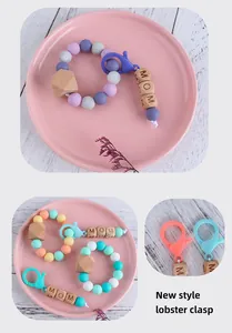 Close-up of silicone beads and MOM wooden block teething bracelet with lobster clasp