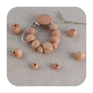 Natural beech wood pacifier clip and DIY bead set on a soft beige linen background