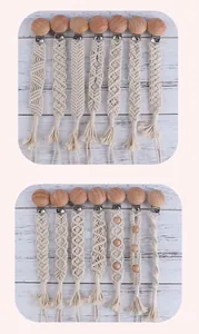 Detailed close-up of handmade macramé pacifier clips with beech wood and cotton rope textures