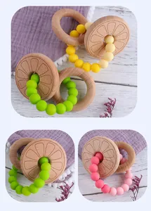 Detail of beech wood baby teething ring with colorful silicone beads and orange slice patterns