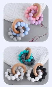 Detail of beech wood ring and colorful silicone beads on soft cotton gauze for baby teething