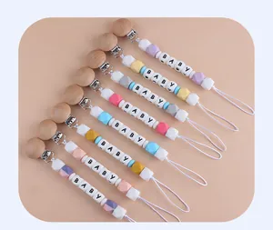 Dettaglio di catenelle per ciuccio per neonati con clip in legno e perle in silicone