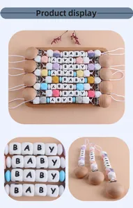 Dettaglio di catenelle portaciuccio in legno e silicone con perline colorate e scritte BABY