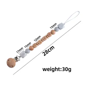 Baby pacifier clip with silicone beads and beech wood pearls featuring BABY engraving