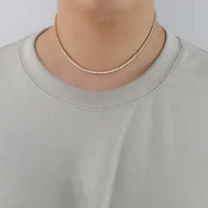Gros plan d'un collier tennis en or 2 mm avec zircons griffés porté par un mannequin