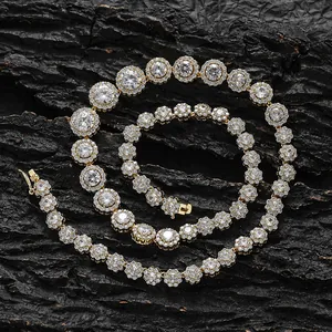 Dettaglio del set collana e bracciale tennis dorati con zirconi floreali su legno nero