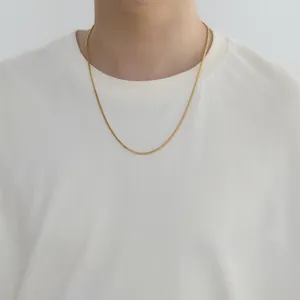 Detail of 2mm golden Franco chain necklace with textured links on a male model