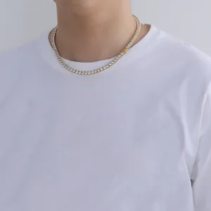 Close-up of a gold tennis necklace with cubic zirconia worn over a white t-shirt