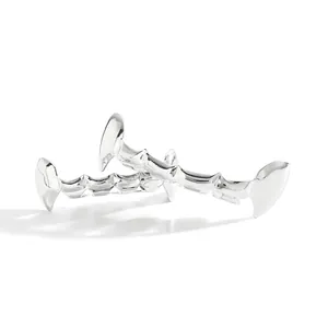 Detailopname van gepolijste zilveren dental grills met spiegeleffect op wit decor