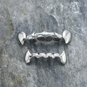Gepolijste zilveren hiphop grillz set met scherpe tanden op grijze stenen achtergrond
