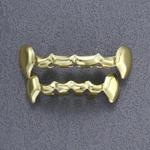 Detail van gouden vampier tanden grillz set voor hiphop op een grijze matte ondergrond