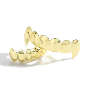 Dettaglio dei grillz hip hop in oro lucido con design a zanne per uno stile da strada