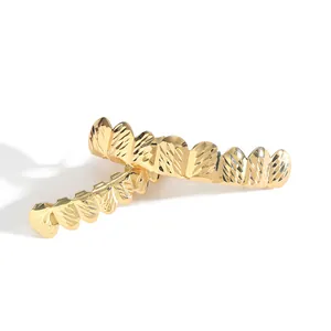 Λεπτομερής προβολή χρυσών hiphop grillz με μεταλλική υφή κοπής διαμαντιού για πάρτι
