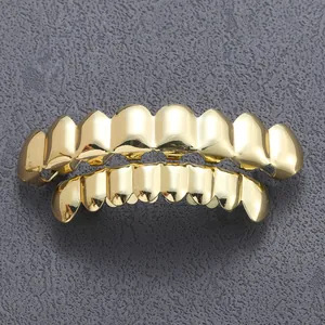 Macro-opname van gepolijste vergulde hiphop grillz op een donkere stenen achtergrond