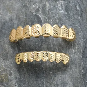 Χρυσό σετ hip hop grillz με ανάγλυφη υφή diamond-cut σε πέτρινο φόντο