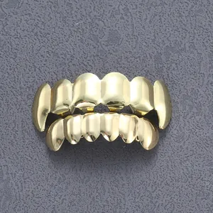 Dettaglio del set di grillz hip-hop in oro lucido per arcata superiore e inferiore su fondo scuro