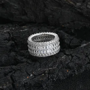 Macro view of iced out ring with baguette and round cut stones on charred wood