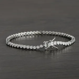 Classic 2mm silver bezel-set tennis bracelet with round cubic zirconia on wood background