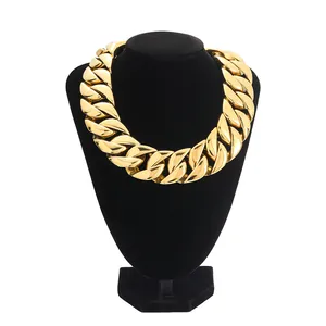 Detailed view of a thick gold Cuban link chain necklace on a black velvet display stand