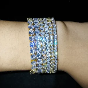 Primer plano de pulseras de tenis bañadas en oro con piedras de circonita brillantes