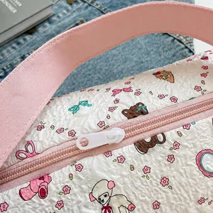 Détail de la fermeture éclair rose et motifs de dessins animés sur le sac blanc