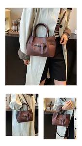Detail of dark brown woven leather bucket bag with metal buckle and shoulder strap