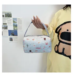 Détail du sac à main matelassé à carreaux bleus avec motifs d'oursons et de fraises