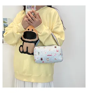 Détail du sac à main à carreaux bleu clair avec motifs d'ours et bandoulière mauve