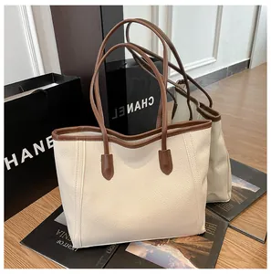 Detail of high-quality lychee pattern faux leather on a stylish cream tote bag with brown straps