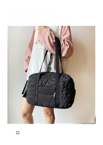 Détail du sac cabas matelassé cœur noir avec poche zippée et longues anses souples