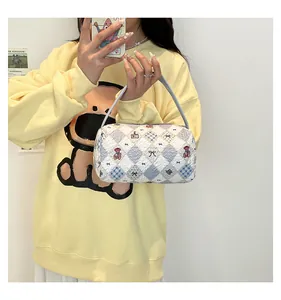 Détail du sac à main blanc gaufré avec motif de losanges bleus et imprimés d'ours