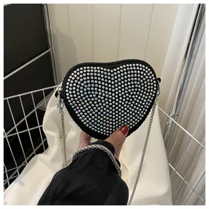 Detail of heart shaped rhinestone crossbody bag with silver chain strap and zipper