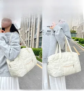 Détail du matelassage en cœur blanc et de la poche latérale pratique du sac cabas