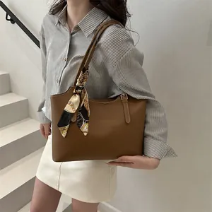 Detail of dark brown tote bag with vintage printed silk scarf on the handle strap
