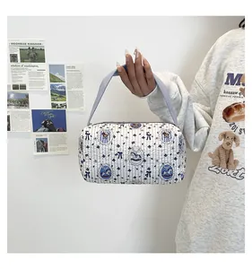 Sac à main cylindrique matelassé avec imprimés d'ours et poignée violette en situation