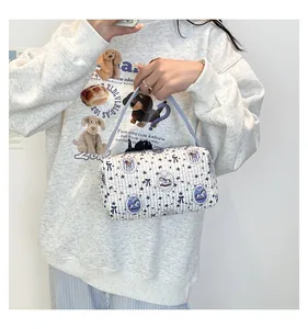 Détail du sac cylindrique matelassé avec imprimés nœuds et chevaux bleus