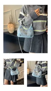 Détail du sac à bandoulière en jean bleu clair avec papillons métalliques et chaîne