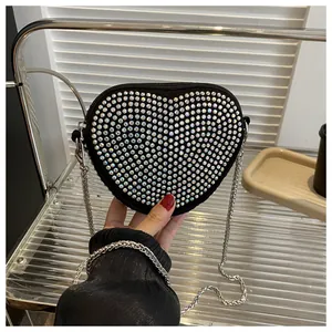 Detail of a sparkling heart-shaped handbag with silver chain strap and rhinestones
