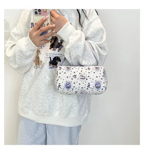 Sac bandoulière cylindrique matelassé à rayures bleues et imprimé carrousel sur un mannequin