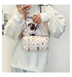 Détail d'un sac à main cylindrique blanc matelassé aux motifs d'animaux colorés