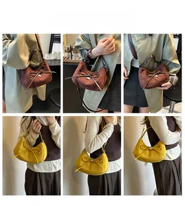 Détail de sacs hobo en demi-lune avec nœud en cuir et pendentif en forme de cœur