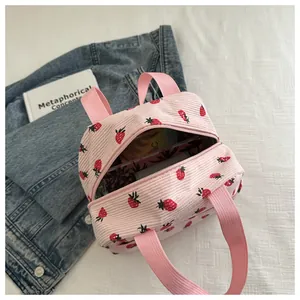 Detailed macro view of pink corduroy lunch bag with cute strawberry pattern and zipper