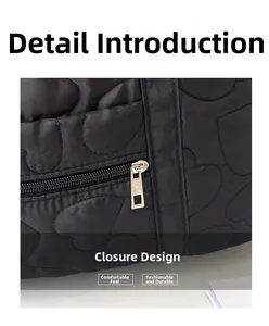 Détail de la fermeture éclair en métal argenté sur le sac bandoulière matelassé noir