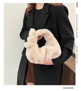 Detailopname van pluizige handtas van imitatiebont met een beige geknoopte handgreep