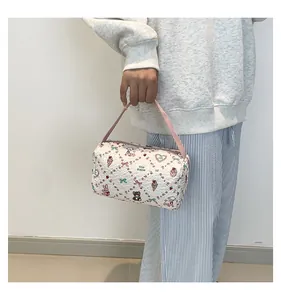 Détail du sac à main matelassé blanc avec motifs ours lapin colorés et anse rose souple