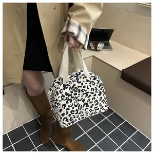 Close-up of stylish leopard print corduroy lunch bag with reinforced cream handles